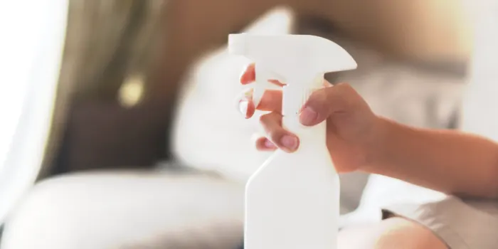 タバコの臭いを消すために消臭剤を持つ人