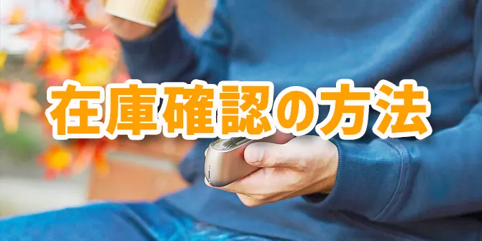 右手に紙コップと右手にアイコスデバイスを持った男性