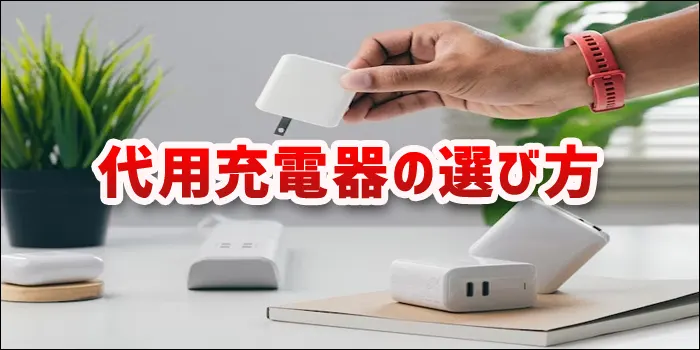 デスク上に複数あるACアダプタの1つを手で拾い上げるシーン