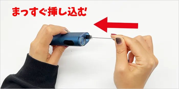 シャッタードアからクリーニングブラシを挿し込んでいる画像