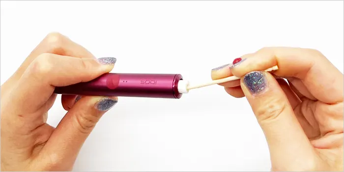 爪楊枝を使って詰まったタバコスティックを取り出している画像