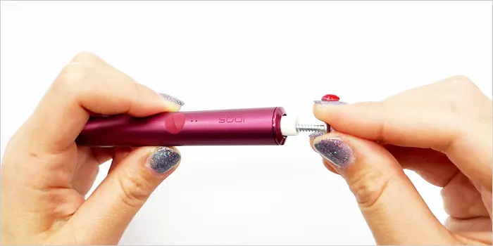 ネジを使って詰まったタバコスティックを取り出している画像