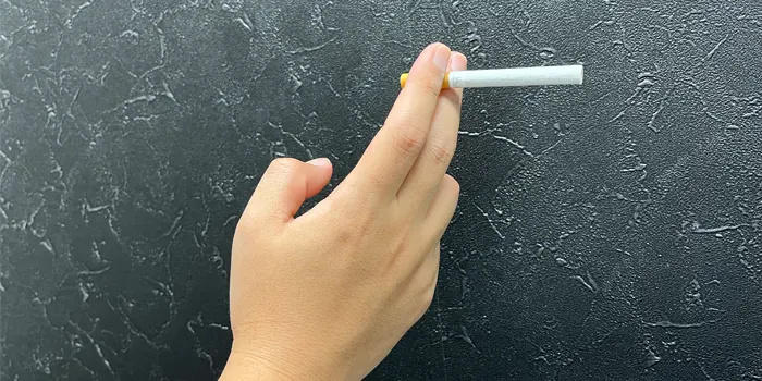 人差し指と中指の先端でタバコを持つ