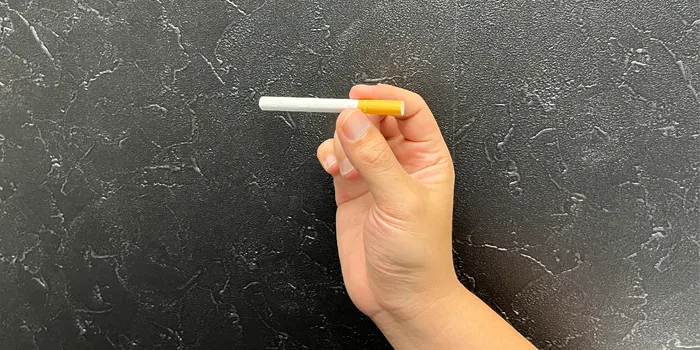 親指と人差し指でタバコをつかむ
