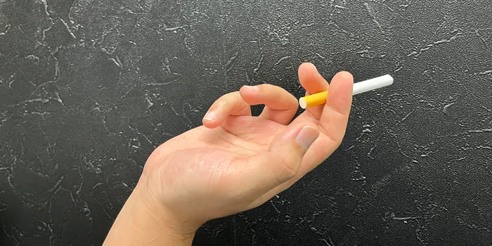 人差し指と中指でタバコを持つ