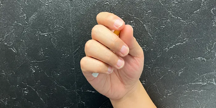 手でタバコを握りこむ