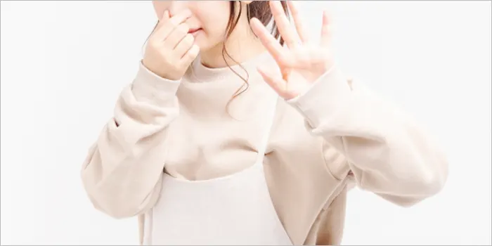 鼻をつまむ女性